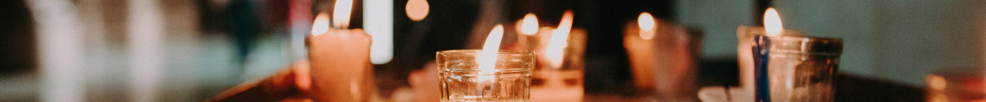 Various burning candles on a table.