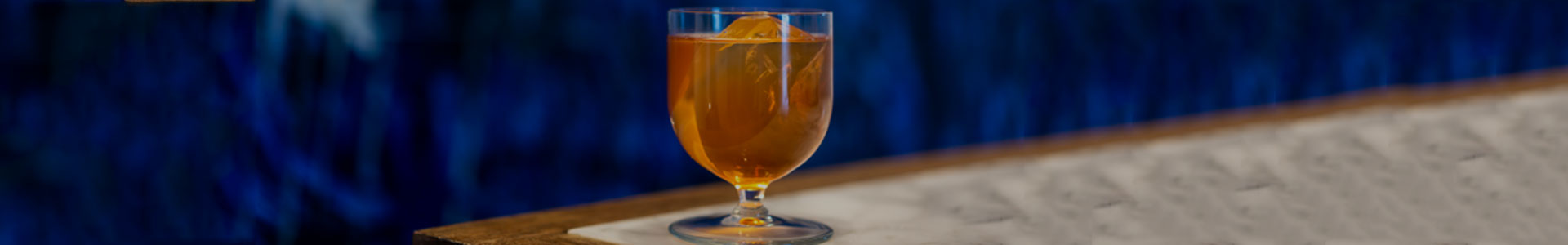 Onis Levitas cocktail glass with orange drink on a table.