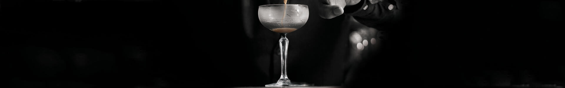 A cocktail glass from Onis is being filled with a cocktail.
