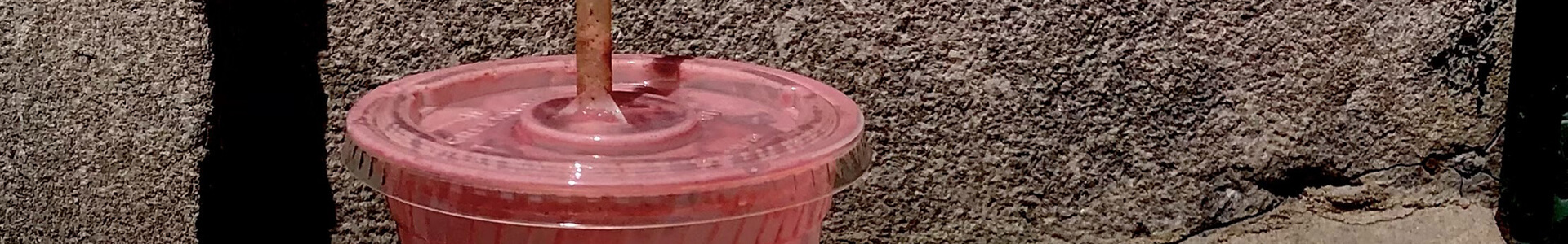 Pink colored drink in a large plastic cup.