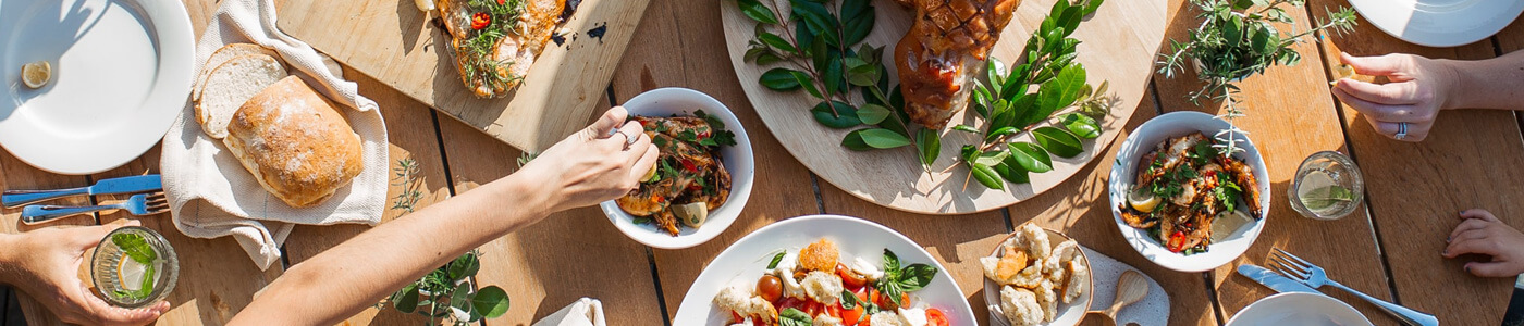 Plates and platters full of food are placed on a table.