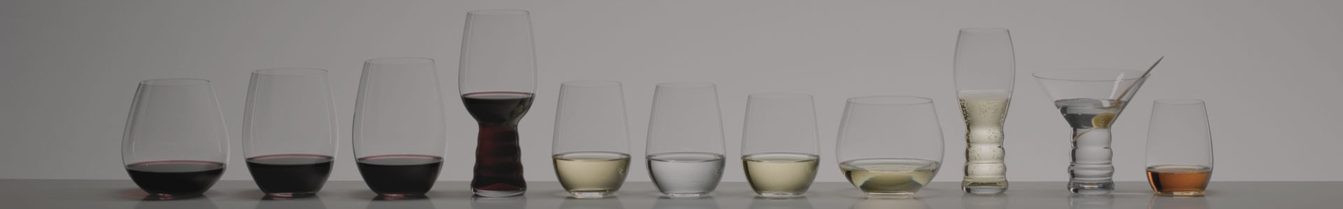 Various glasses from the series O by manufacturer Riedel stand next to each other.