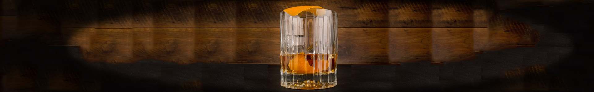 Tumbler with whisky and orange zest.